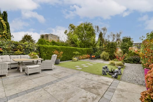 A serene garden featuring a comfortable seating area, vibrant plants, and decorative features, perfect for relaxation and outdoor gatherings.