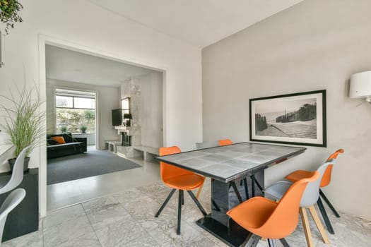 A sleek modern dining area featuring stylish furniture, a contemporary table, and minimalist decor, creating a warm and inviting atmosphere for meals.