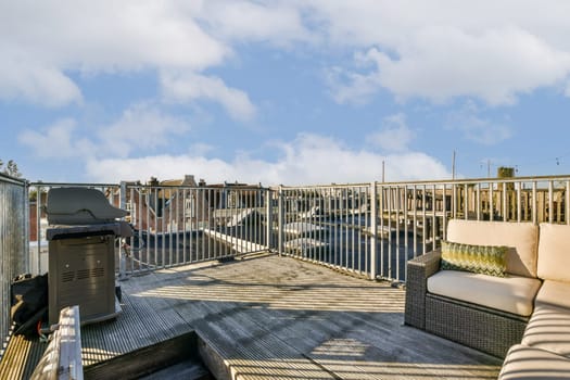 An inviting rooftop patio featuring modern furniture, a grill, and a stunning view of the city skyline, perfect for gatherings or relaxation.