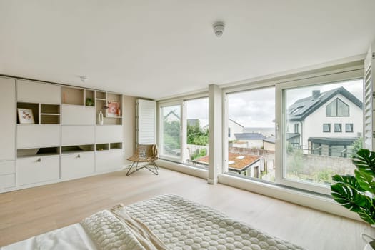 A bright and airy indoor living area featuring modern furniture, large windows, and greenery. This design emphasizes comfort and contemporary style.