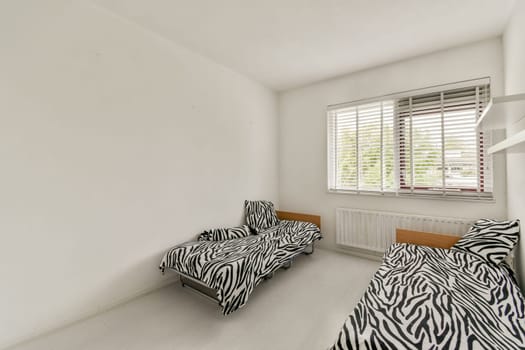 A bright, minimalist interior showcasing simple furniture with striped patterns against stark white walls and natural light filtering through the window.