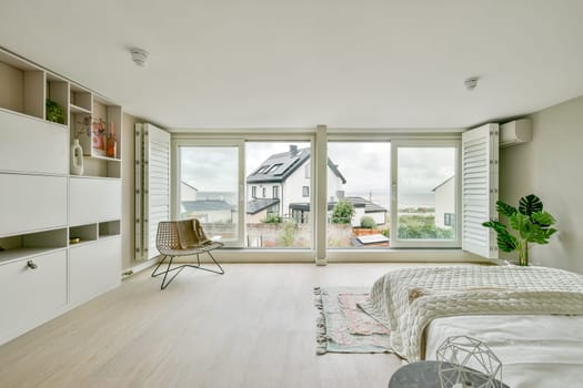 A bright, spacious room featuring minimalist furniture and large windows allowing natural light to flow in, creating an inviting atmosphere perfect for relaxation.