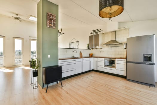 A stylish modern kitchen featuring sleek cabinetry, contemporary appliances, and abundant natural light from spacious windows, creating a welcoming cooking space.