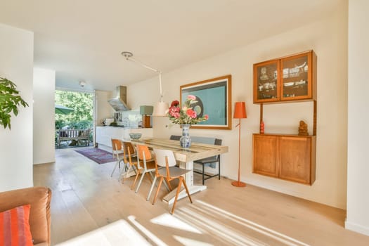 A bright and airy modern dining room featuring a wooden table, chairs, and stylish decor, perfect for gatherings and family meals.