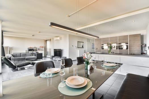 A stylish modern dining area featuring a glass table, plush seating, and contemporary decor, promoting a warm and inviting atmosphere for gatherings.