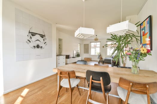 A spacious interior design featuring modern furniture, a decorative wall art piece, and vibrant flowers creating a welcoming atmosphere.