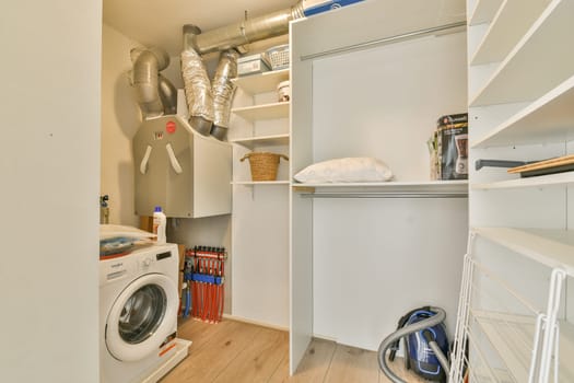 A sleek and organized laundry room featuring a washing machine, shelves for storage, and a tidy environment. Ideal for efficient laundry tasks.