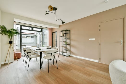 A contemporary dining space featuring stylish furnishings and ample natural light. The design emphasizes simplicity and elegance, creating a welcoming atmosphere.