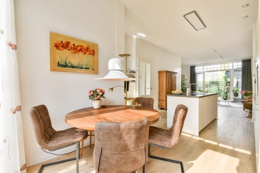 A bright and inviting dining area featuring a wooden table, comfortable chairs, and colorful artwork, creating a warm and welcoming atmosphere.