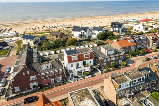 The image showcases a picturesque aerial view of a beach town, featuring residential houses, sandy beaches, and a vibrant coastal atmosphere.