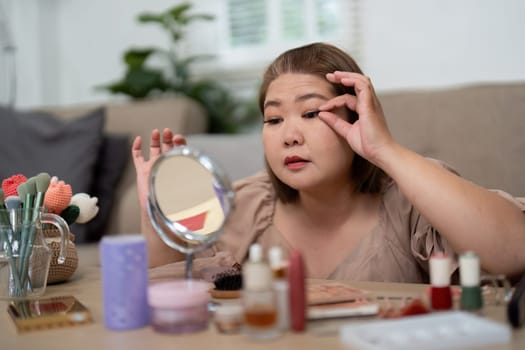 With focus and precision, she delicately places eyelash extensions, creating a stunning look as she admires her progress.