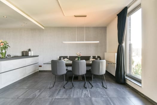 This modern kitchen features sleek cabinetry and a stylish dining area with elegant seating, perfect for contemporary living. The open layout enhances functionality.