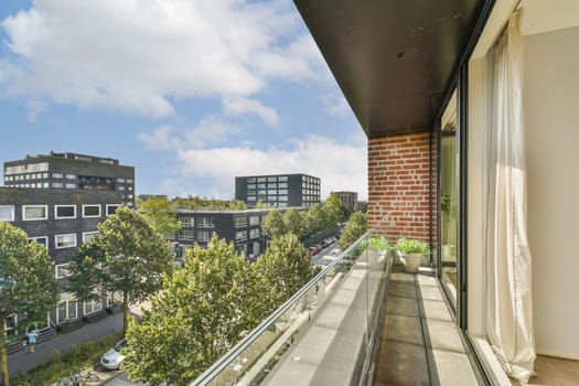 An inviting view from a modern balcony overlooking a bustling city street adorned with greenery and contemporary architecture under a bright sky.