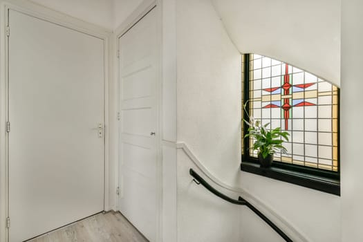 A well-designed interior featuring a stained glass window, a serene ambiance, and soft natural light illuminating the staircase area.