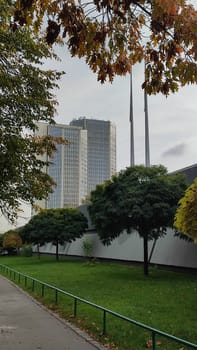 Building trees walkway modern architecture street opendoor green nature park summer tree trees grass city centre town landscape background landmark stone material garden flora botanical gardens park . High quality photo