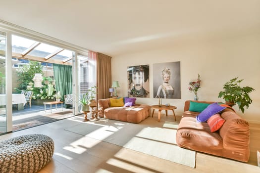 A contemporary living room featuring stylish furniture, large windows, and vibrant decor, promoting a warm and welcoming atmosphere.