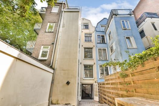 A picturesque view of two distinct styles of urban buildings framed by lush greenery, showcasing modern architectural design and inviting outdoor spaces.