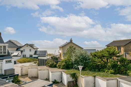 A picturesque coastal scene featuring elegant houses against a backdrop of a serene sea and cloudy sky. A perfect blend of nature and architecture.