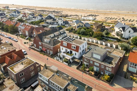 The image showcases a picturesque coastal area with charming houses lining the beach. The vibrant scene captures the essence of seaside living.