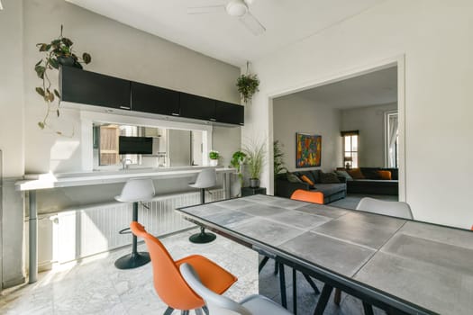 Bright and open space featuring contemporary furniture and plants, showcasing a stylish dining area complemented by natural light and a comfortable living room.