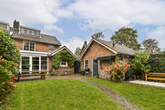 A picturesque residential scene featuring two cozy houses surrounded by lush greenery and a welcoming garden pathway. Perfect blend of nature and architecture.