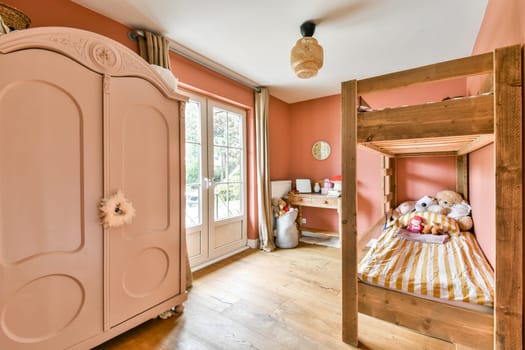 A charming and cozy children's bedroom featuring a wooden bunk bed, pink walls, and a lovely wardrobe. Perfect for adding warmth and comfort to any space.