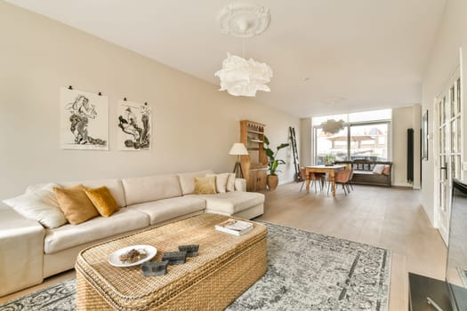 Spacious living room showcasing contemporary furniture, natural lighting, and a harmonious blend of textures. The design fosters comfort and style, creating an inviting atmosphere.