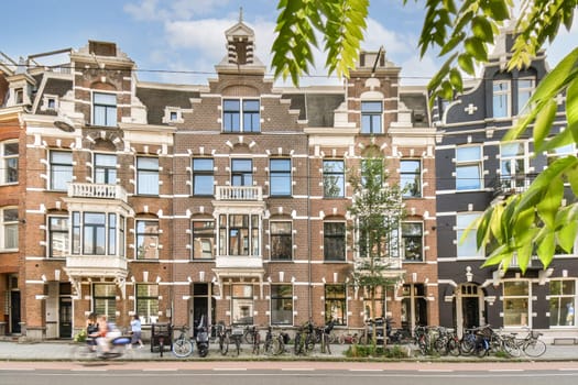 A picturesque scene featuring traditional Dutch buildings adorned with intricate designs, bicycles lined up in front, and a clear blue sky.