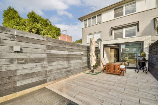 A stylish courtyard featuring wooden accents, modern furniture, and lush greenery, perfect for relaxation and social gatherings.