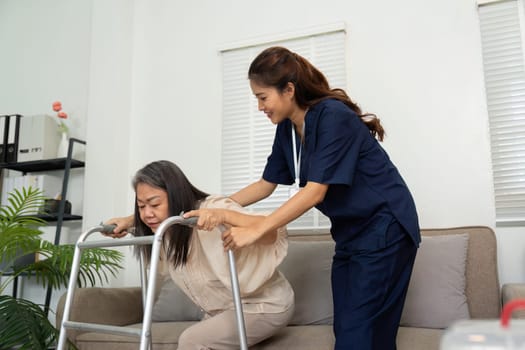 A caregiver gently encourages an elderly woman as she uses her walker, emphasizing safety and confidence during mobility.
