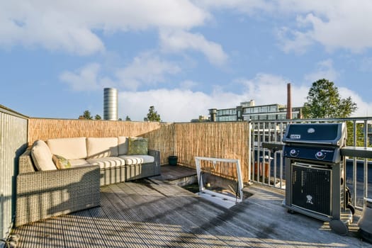 An inviting outdoor balcony featuring modern furniture, a grill, and a scenic view, perfect for relaxation and gatherings.