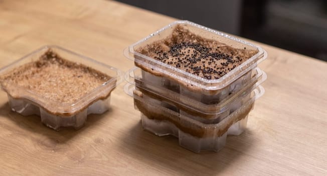 Stacked plastic containers with watered seeds of micro greens on jute mats