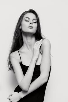 Sophisticated female model with long hair and a serene expression, capturing a mood of elegance and poise in a minimalist black and white setting.