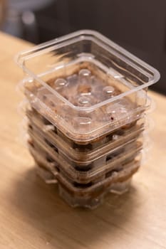 Stacked plastic containers with watered seeds of micro greens on jute mats