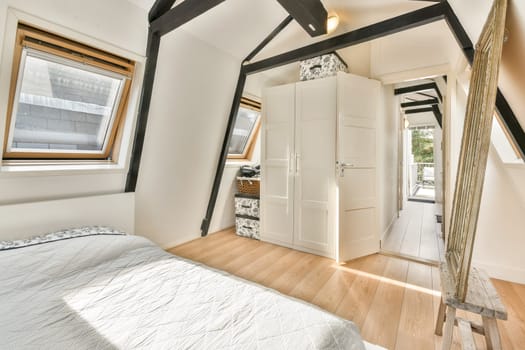 A sleek modern bedroom interior featuring wooden flooring, large windows, and minimalist decor enhancing natural light and spaciousness.