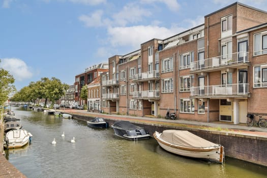 A picturesque scene showcasing a serene canal lined with charming buildings and boats, surrounded by lush greenery under a clear blue sky.
