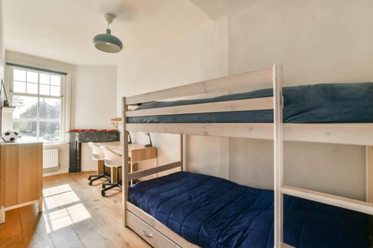 A bright and inviting bedroom featuring wooden bunk beds, a study area, and warm sunlight streaming through the window, creating a serene atmosphere.