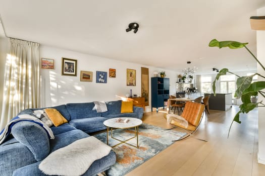 A stylish and airy modern living room featuring a cozy couch, artwork on the walls, and plants, creating a welcoming atmosphere for relaxation and social gatherings.