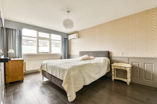 This modern bedroom features a light color palette, a comfortable bed, wooden flooring, and stylish curtains, creating a serene and inviting atmosphere.