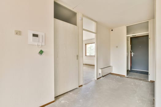 A spacious, modern entrance hallway showcasing stylish flooring, minimalistic design, and ample natural light from large windows.