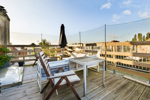 A beautifully designed rooftop deck featuring modern outdoor furniture, gentle sunlight, and greenery that creates a serene urban retreat.