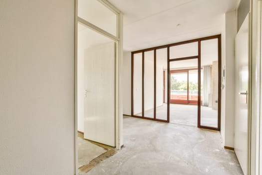 A spacious and modern interior featuring transparent partitions and natural lighting, ideal for contemporary living spaces. The simplicity enhances the openness of the design.