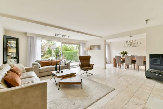A stylish modern living room featuring elegant furniture, large windows, and a warm color palette that creates an inviting atmosphere for relaxation and social gatherings.