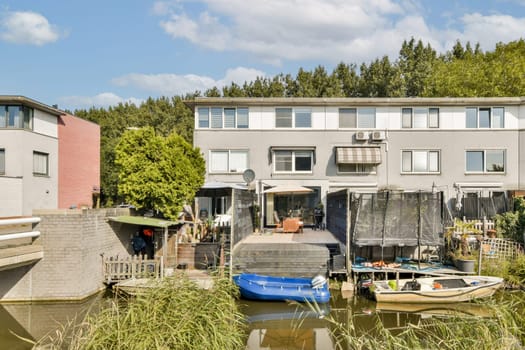 Scenic view of riverside houses showcasing modern architecture alongside boats. Lush greenery enhances the peaceful ambiance in this residential area.