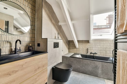 A stylish and contemporary bathroom featuring sleek lines, a modern bathtub, minimalist cabinetry, and natural light streaming through the windows.