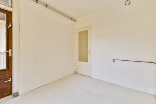A simple, clean indoor space featuring a plain wall and an open door. The aesthetic reflects minimalism with neutral tones.