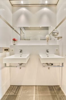 A sleek and contemporary bathroom featuring dual sinks, elegant fixtures, and a minimalist design aesthetic highlighted by bright lighting and clean lines.
