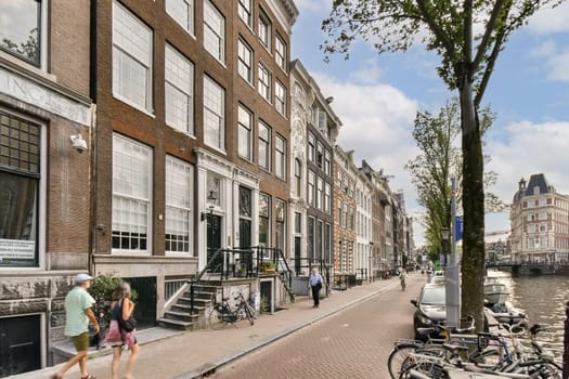 Stroll along the picturesque canal streets of Amsterdam, lined with historic buildings, lively pedestrians, and serene reflections on the water.