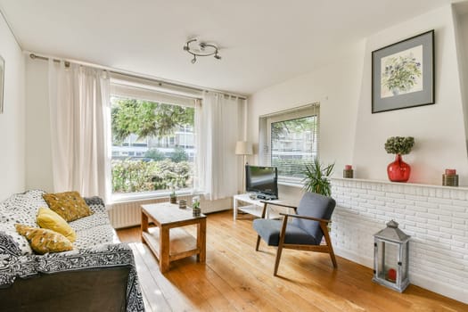 This bright and airy living room features large windows, stylish furniture, and a welcoming atmosphere, perfect for relaxation and socializing.