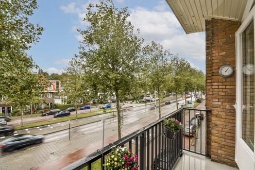 Overlooking a serene street lined with trees, this image captures the essence of urban living, blending nature with the cityscape and showcasing a peaceful atmosphere.